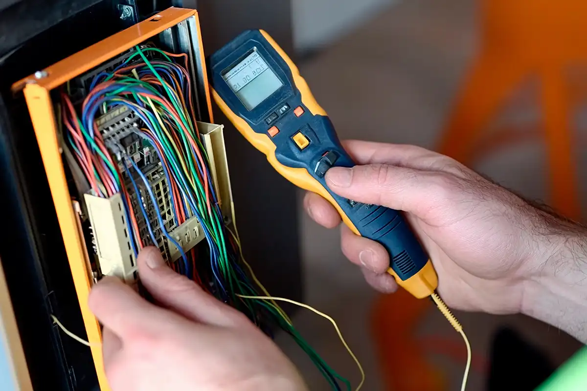 an electrician performing a PAT test on a fuse box