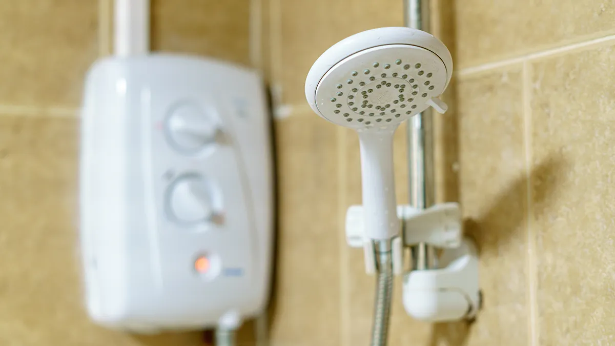 an electric shower on beige tiles in a bathroom