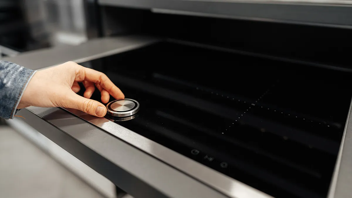 Woman testing a newly installed electric hob
